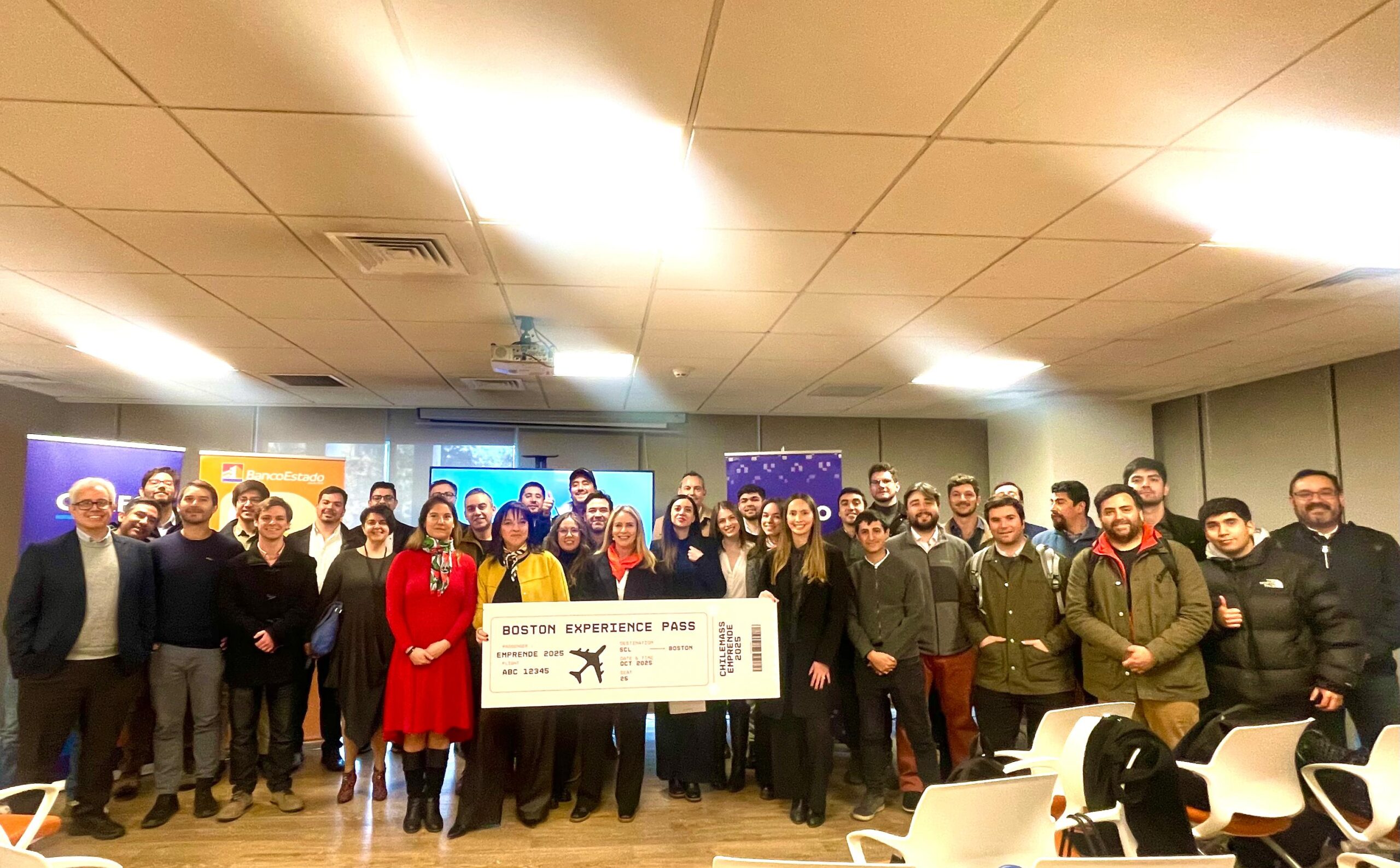 Group photo of the ChileMass Emprende 2025 winners and organizers holding a symbolic Boston Experience Pass ticket during the finalists’ announcement event at BancoEstado headquarters.